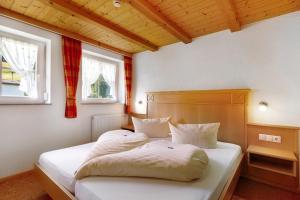 a bedroom with a bed with white sheets and two windows at Danielenhof in Freiamt +58 photos