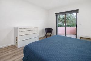 a bedroom with a bed and a dresser and a window at Windmill Açores Suite in Furnas