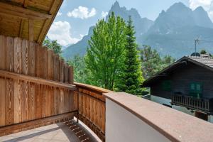 a balcony with a wooden fence with mountains in the background at Villa Nussbaumer in Siusi
