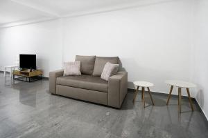 a living room with a couch and two tables at Windmill Açores Suite in Furnas