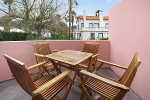a wooden table and chairs on a balcony at Windmill Açores Suite in Furnas