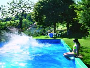 a woman sitting on a raft in a swimming pool at Schornhof in Oberwolfach