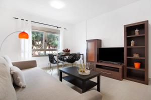 a living room with a couch and a tv at Puerto Playa 2 in Puerto del Rosario