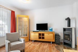 a living room with a television and a chair at Ferienwohnung Am Straussee in Strausberg