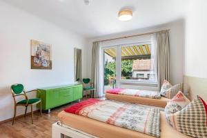a bedroom with three beds and a window at Ferienwohnung Am Straussee in Strausberg