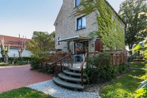an ivy covered house with stairs leading up to it at Ferienwohnung Am Straussee in Strausberg