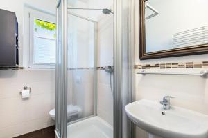 a bathroom with a shower and a sink and a toilet at Ferienwohnung Am Straussee in Strausberg +16 photos