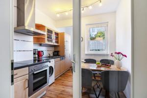a kitchen with a wooden table and a dining room at Ferienwohnung Am Straussee in Strausberg