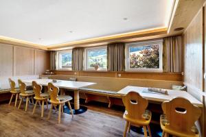a row of tables and chairs in a room with windows at Danielenhof in Freiamt