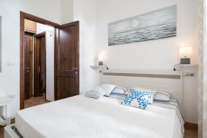 a bedroom with a large white bed with blue pillows at Appartamento da Manzela 2 in Cala Gonone