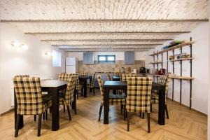 a dining room with black tables and yellow chairs at Margarethengasse Comfort Rooms Old Town in Sibiu +25 photos