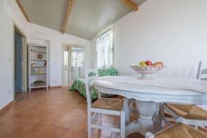 a dining room with a white table and chairs at Medusa Apartment in Taormina +16 photos