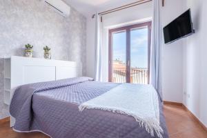 a bedroom with a bed and a large window at Medusa Apartment in Taormina