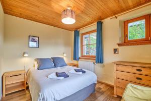 a bedroom with a bed and a wooden ceiling at Chalet il fera beau demain in Villard-Reculas +108 photos