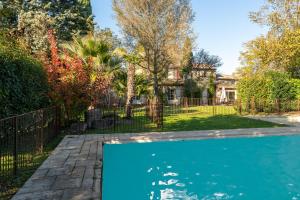 a swimming pool in a yard with a fence at La Rivière in Velleron