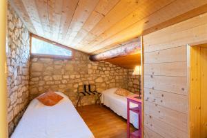 a bedroom with two beds in a room with wooden walls at La Rivière in Velleron +20 photos