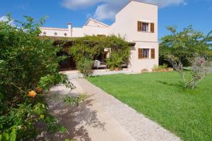 a white house with a garden and a pathway at Finca Port Vert in Son Servera
