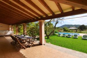 a patio with a table and chairs and a pool at Finca Port Vert in Son Servera