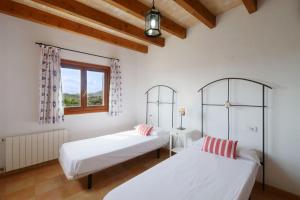two beds in a room with a window at Finca Port Vert in Son Servera