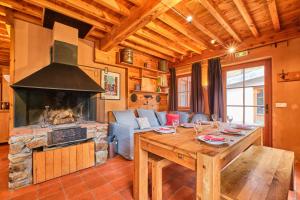 a living room with a table and a fireplace at Chalet il fera beau demain in Villard-Reculas