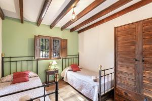 two beds in a room with green walls and wooden ceilings at La Finca de Teror in Teror +18 photos