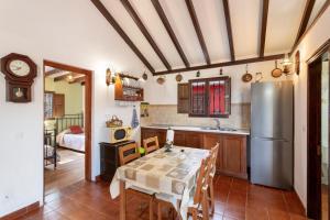 a kitchen with a table and a refrigerator at La Finca de Teror in Teror