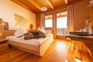 a bedroom with a bed in a room with wooden walls at Rossalm in Brixen