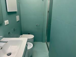 a bathroom with a toilet and a sink and a shower at Bruseschi Appartament in Grado +8 photos