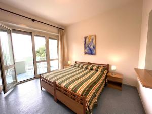 a bedroom with a bed and a large window at Bruseschi Appartament in Grado