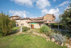 a house with a green umbrella in the yard at La Farneta in Monteriggioni