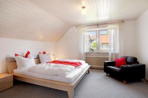 a bedroom with a bed and a chair and a window at Ferienwohnung Lange in Waldstetten