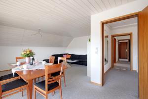 a dining room and living room with a table and chairs at Ferienwohnung Lange in Waldstetten