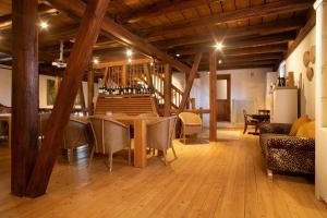 a room with a table and chairs and wooden ceilings at Villa Puppenhaus in Immenstaad am Bodensee