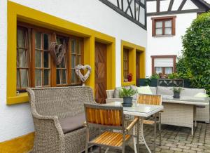 a patio with wicker chairs and a table and a building at Villa Puppenhaus in Immenstaad am Bodensee