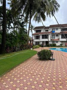 a person walking down a path next to a resort at Cim and Sands in Goa