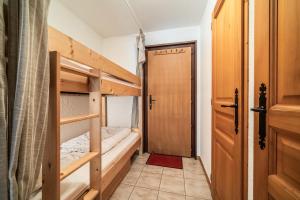 a small room with two bunk beds and a door at Studio Rez-de-jardin, 4 pers Chatel in Châtel