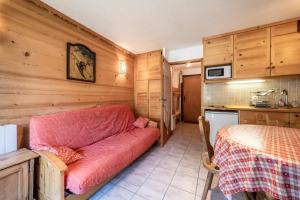 a living room with a red couch in a kitchen at Studio Rez-de-jardin, 4 pers Chatel in Châtel +14 photos