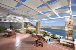 a patio with chairs and a view of the water at Villa Crysta Mykonos in Mikonos