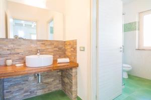 a bathroom with a sink and a toilet at Casa Orchidea in Calatabiano +16 photos