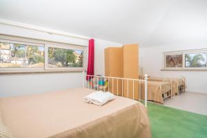 a room with two beds and two windows at Casa Orchidea in Calatabiano