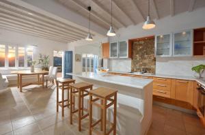 a kitchen with wooden cabinets and a table and chairs at Villa Crysta Mykonos in Mikonos