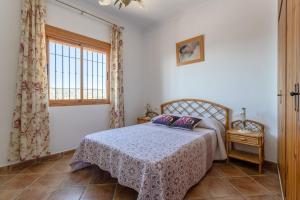a bedroom with a bed and a window at Casa rural Villena in Frigiliana
