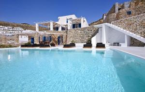 a swimming pool in front of a villa at Villa Crysta Mykonos in Mikonos