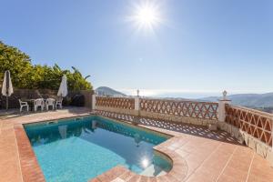 a swimming pool on a patio with a view of the ocean at Casa rural Villena in Frigiliana