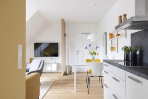 a kitchen with white cabinets and a living room at Strandhafer in Böhl