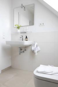 a white bathroom with a sink and a toilet at Strandhafer in Böhl