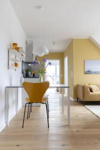 a living room with a table and a yellow chair at Strandhafer in Böhl +27 photos