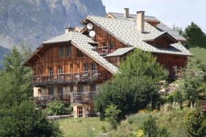 a large wooden house on top of a mountain at Chalet il fera beau demain in Villard-Reculas