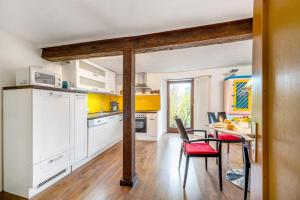 a kitchen with white cabinets and a table with chairs at Ferienwohnung Kaleidoskope in Buhlenberg