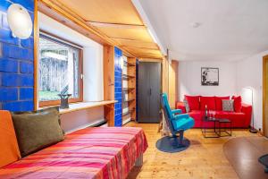 a living room with a red couch and a red chair at Ferienwohnung Kaleidoskope in Buhlenberg